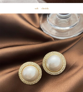Macro shot of luxury pearl earrings with sparkling diamond halo on silk fabric