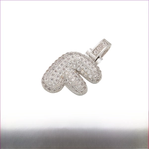 Macro detail of iced-out bubble letter E pendant with clear stones and rhodium plating