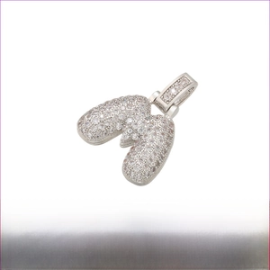 Macro detail of silver Rhodium plated letter M pendant with iced out cubic zirconia