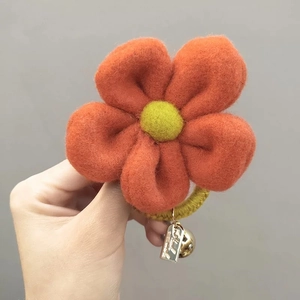 Handmade orange felt flower hair tie with yellow woven elastic band and small gold bell