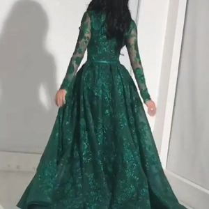 Elegant dark green lace evening gown featuring a full skirt and long sleeves from back view