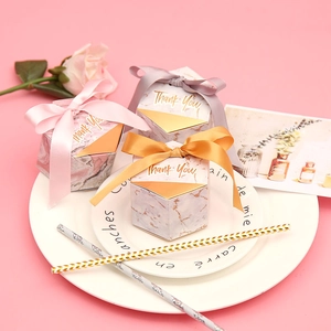 Detail of marble pattern hexagon gift boxes with silk ribbons and gold Thank You lettering