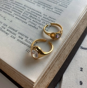 Close-up of two gold-plated 925 silver rings with large oval zircons on an open vintage book
