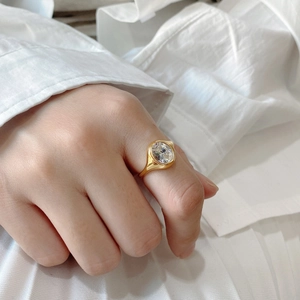 Close-up of a minimalist gold ring with a large round-cut sparkling zircon on hand