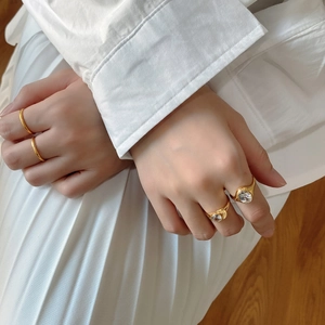 Detailed macro view of gold-plated rings set with oval cubic zirconia on a model hand