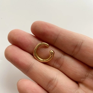 Minimalist lava irregular gold plated ear cuff held by hand to show size and scale