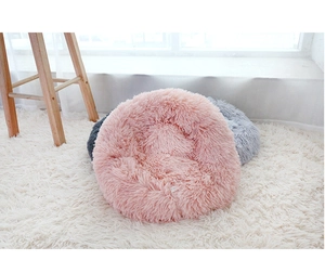 Plush round pet beds in pink and grey colors on a soft carpet for cats and small dogs