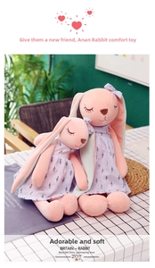 Detail of two plush bunny dolls in floral dresses with soft texture and long ears