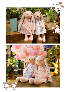 Close-up of pink and blue plush rabbits with long ears wearing patterned dresses