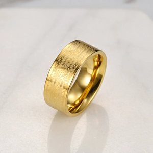 Dettaglio macro di anello in acciaio inox dorato 8mm con logo massonico su marmo