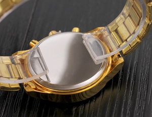 Detailed back view of a gold alloy watch featuring a polished silver metal case back