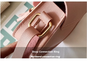 Detail of pink leather mini bag featuring gold hardware loops and fine stitching detail