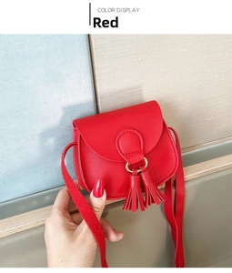 Close-up of a red mini kid bag with round flap and decorative gold tassel details