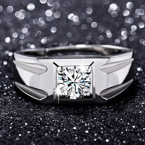Macro shot of men's silver ring with round-cut zircon and embossed wing design