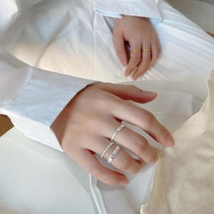 Detail of elegant 925 sterling silver stacked rings on hand with minimalist textures
