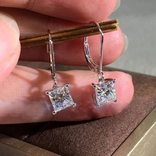 Detail showing sea turtle drop earrings with sparkling cubic zirconia on a brown display box