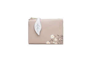 Close-up of pink PU leather wallet with daisy print and white leaf zipper pull detail