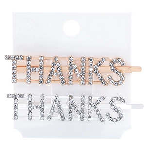 Close-up of gold and silver THANKS letter hair clips with rhinestones on a white card
