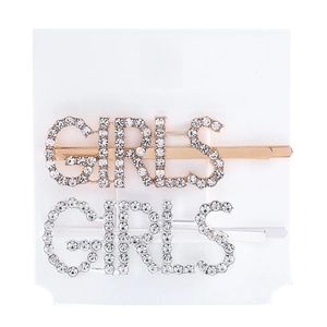 Close-up of metal hair clips with GIRLS letters and sparkling rhinestones set on card