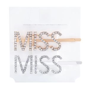 Close-up of gold and silver MISS letter hair clips with rhinestones on a display card