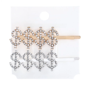 Detail of gold and silver hair pins featuring four rhinestone dollar signs on a white card