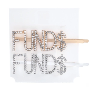 Detail of gold and silver letter hair clips with rhinestones spelling FUND$