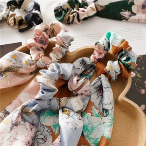 Close-up of floral print hair scrunchies with long ribbons in a wooden heart tray