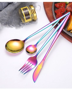 Rainbow-plated stainless steel cutlery set with fork, spoon, and knife on a white table
