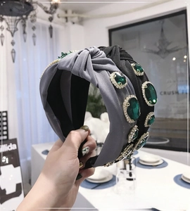 Close-up of Baroque knotted headbands featuring emerald green gems and sparkling crystals