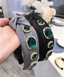 Close-up of Baroque knot headband with emerald green gemstones and sparkling crystals