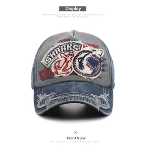 Front view of distressed washed denim baseball cap with shark and anchor embroidery details