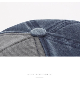 Close-up of crown button and reinforced stitching on a navy blue washed cotton baseball cap