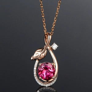 Detailed view of rose gold leaf pendant with pink gemstone and small diamond accent