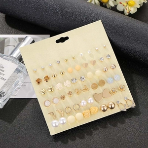 Flat lay of multiple stud earring sets featuring crystals and pearls on a display card