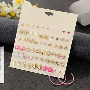 Macro shot of a 30-pair fashion earring set with floral, star, and pearl designs