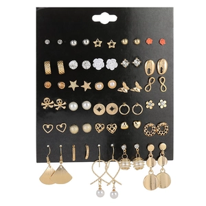 Close-up of 30 pairs assorted gold and silver fashion stud earrings on black card