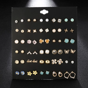 Detail view of 30 pairs gold alloy stud earrings set with crystals and faux pearls