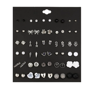 Detailed grid of 30 pairs of assorted crystal and pearl stud earrings on a display card