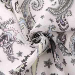 Macro detail of white linen scarf with paisley prints and black star patterns