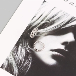 Detailed close-up of S925 sterling silver chain link hoop earrings on a magazine background