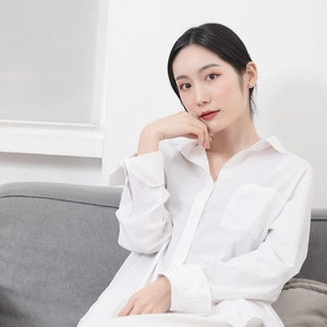 Detailed view of white long sleeve collared cotton shirt with front pocket on casual model
