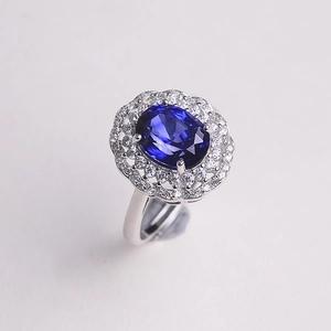 Detailed macro view of the silver halo ring featuring a large oval blue gemstone
