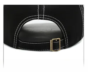 Detail of black baseball cap with contrast stitching and adjustable metal buckle strap