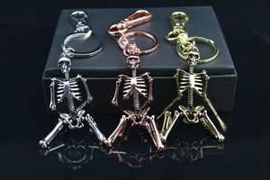 Detail view of metal skeleton keychains in silver, rose gold, and gold finishes