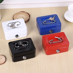 Mini metal money boxes in four colors with keys and top handles on a wooden surface