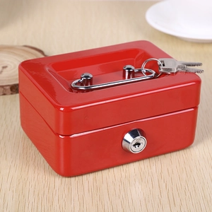 Detailed view of red metal cash box with silver handle and keys on a wooden desk