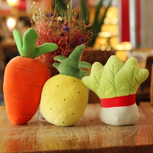 Three plush toys featuring carrot pineapple and cabbage on a wooden table