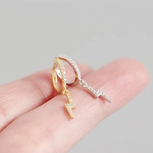 Close-up of S925 sterling silver lightning bolt hoop earrings with cubic zirconia on fingers