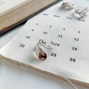 Macro detail of irregular S925 sterling silver liquid-style ring with hallmark engraving