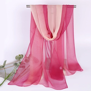 Detail of thin gradient rose red chiffon scarf hanging on a metal support rack